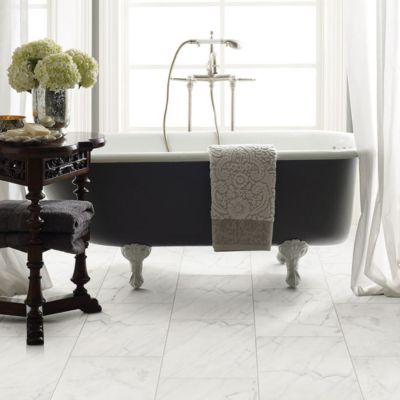 marble tile flooring in a bright white bathroom with a tub